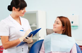 A young female patient is talking with a dentist