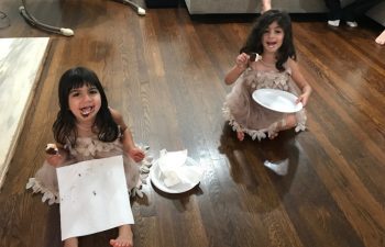 Two girls sitting on the floor and eating ice cream